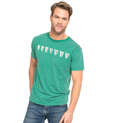 A man wearing an Evolution Harp Green Tee by Guinness.
