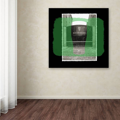 A Guinness Brewery 'Guinness XIV' canvas art portraying a black and green painting on a wall in a room.